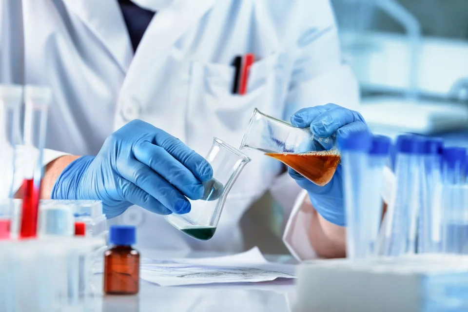 A scientist experimenting with chemicals in beakers