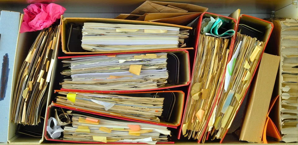 Stacks of binders overflowing with documents