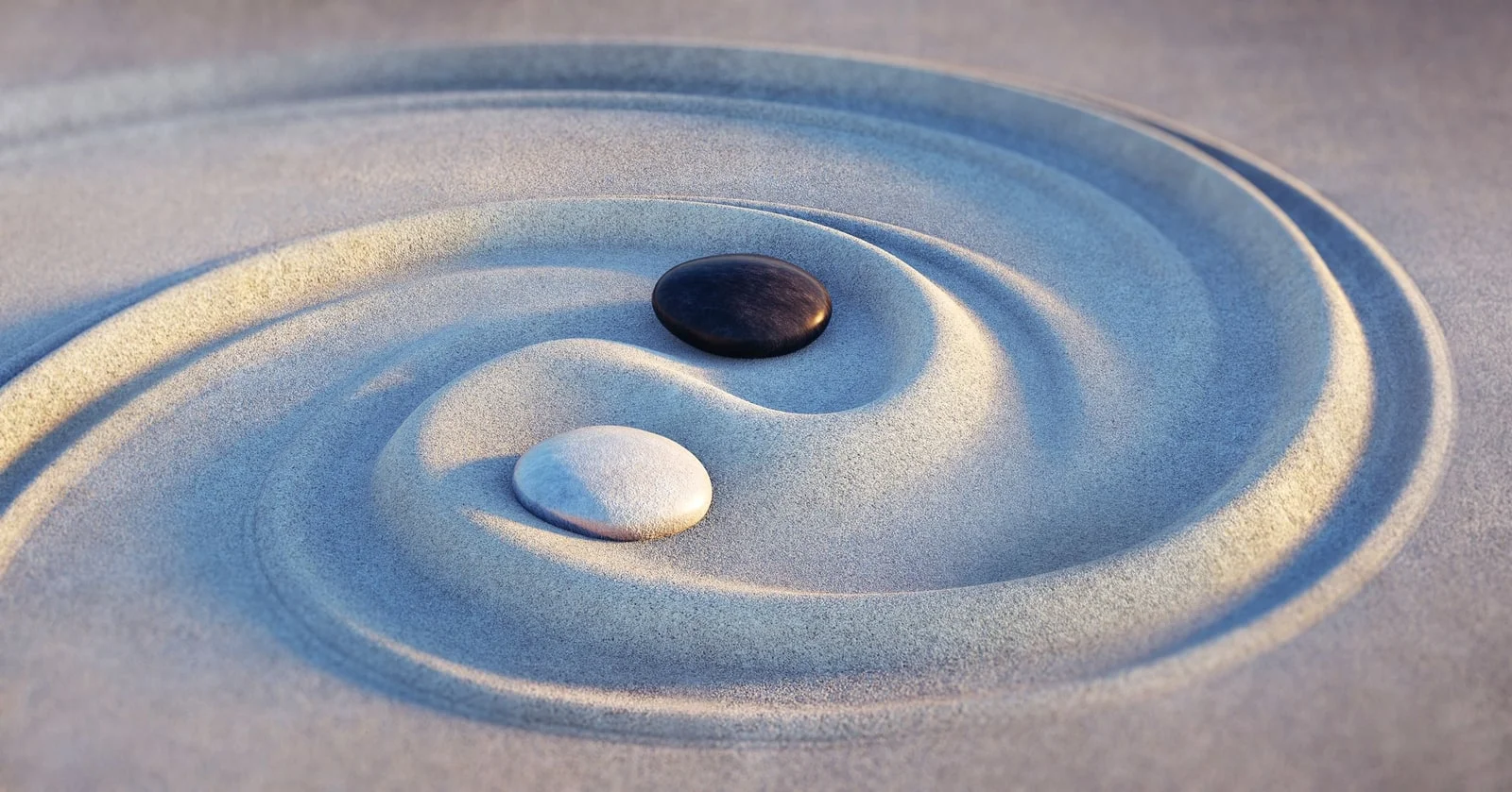 Black and white pebbles in a swirling sand yin yang