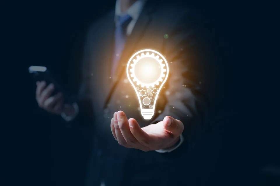 A man holding a lit lightbulb