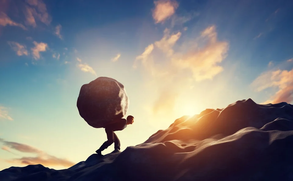 Man carrying a boulder, akin to Sisyphus